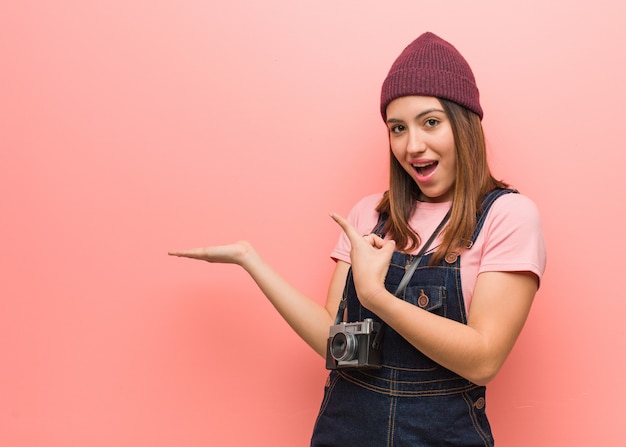 Jeune femme photographe mignon tenant quelque chose avec la main