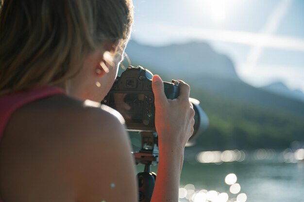 Jeune femme photographe prenant des photos de la belle nature estivale au bord de la mer