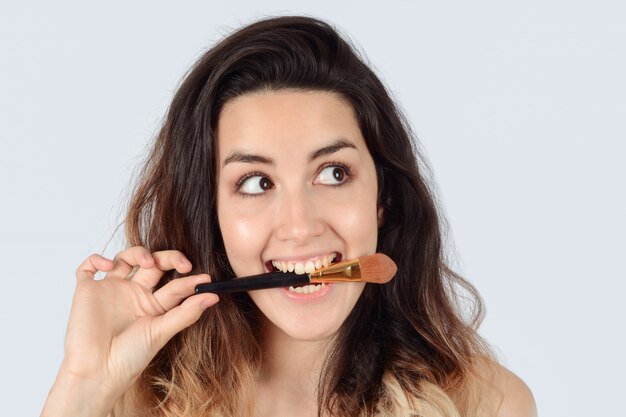 Jeune femme avec un pinceau de maquillage