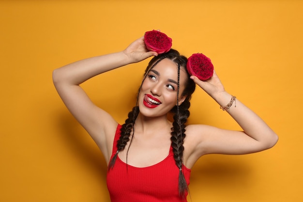 Jeune femme avec pitahaya frais sur fond jaune Fruits exotiques