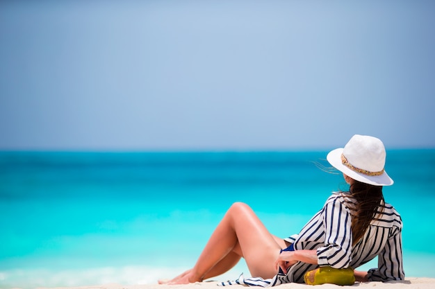 Jeune femme sur une plage blanche avec noix de coco