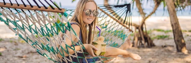 Jeune femme sur la plage dans un hamac avec une bannière de boisson format long