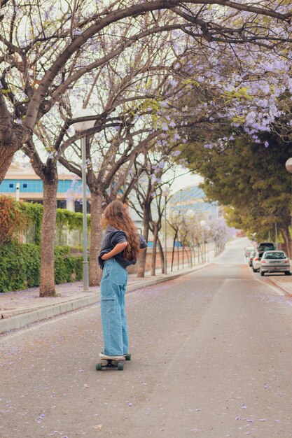 Jeune femme planches à roulettes sur la route d'une rue