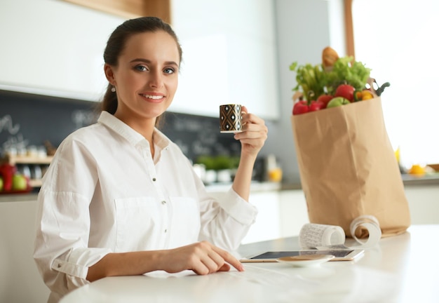 Jeune femme planifiant les dépenses et payant les factures de sa cuisine