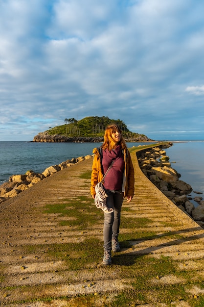 Photo une jeune femme sur le podium pour se rendre à l'île san nicolas à marée basse depuis la plage d'isuntza à lekeitio, pays basque