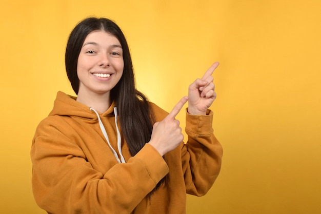 Une jeune femme pointe vers la droite avec sa main droite