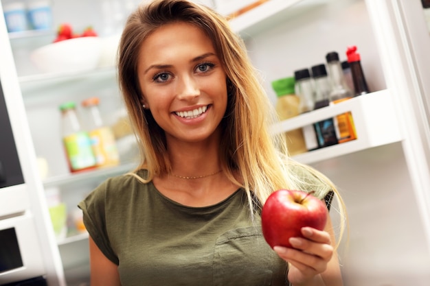 jeune femme, à, pomme, sur, réfrigérateur