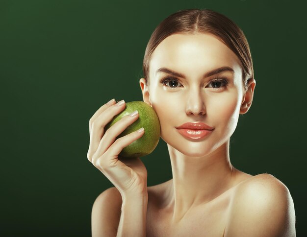 Jeune femme avec pomme verte sur fond vert