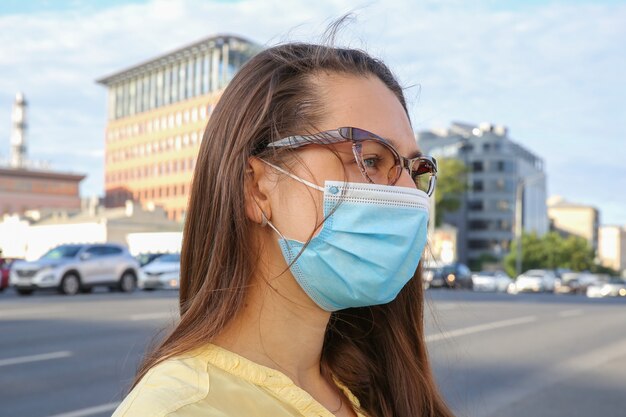 Jeune femme portant des lunettes et un masque de protection