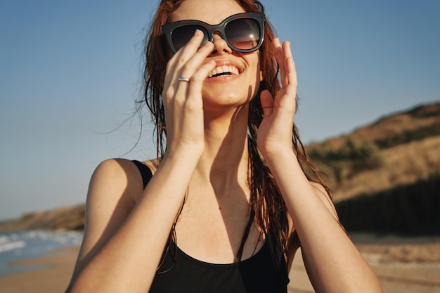 Une jeune femme portant des lunettes de soleil alors qu'elle se tient contre le ciel