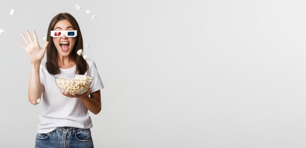 Une jeune femme portant des lunettes de soleil sur un fond blanc