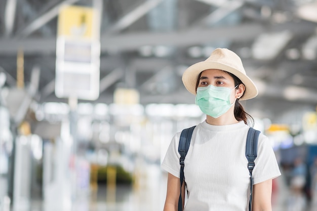 Jeune femme portant un masque chirurgical à l'aéroport