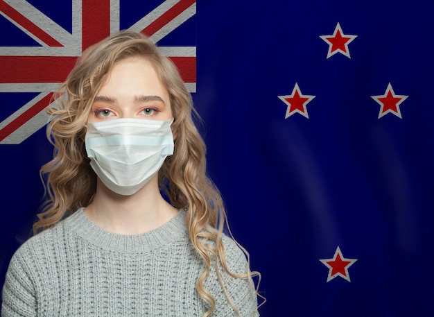 Une jeune femme portant un masque avec le drapeau de la Nouvelle-Zélande Concept d'épidémie de grippe et de protection contre le virus