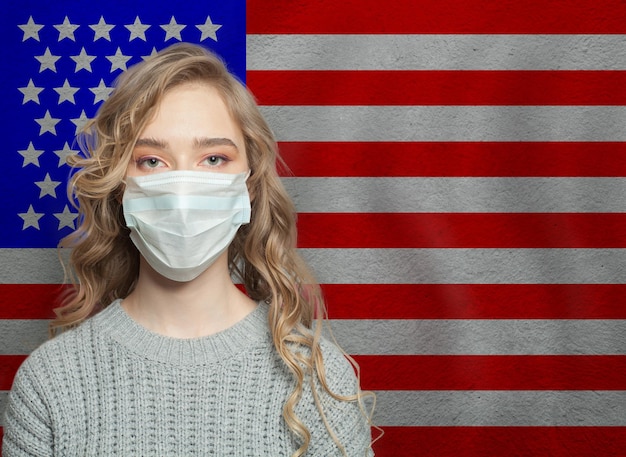 Une jeune femme portant un masque facial avec le drapeau des États-Unis Concept d'épidémie de grippe et de protection contre le virus