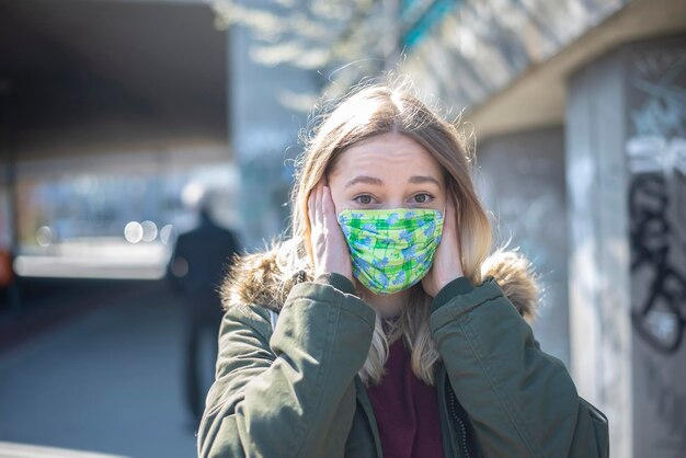 Une jeune femme portant un masque se tient dans la ville