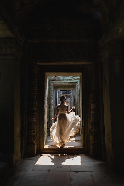 Jeune femme portant une robe robe blanche dans les anciennes ruines khmères Angkor Wat