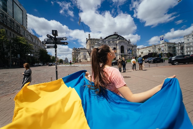 La jeune femme porte le drapeau de l'Ukraine flottant derrière elle