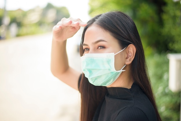 Jeune femme porte un masque facial en ville en plein air