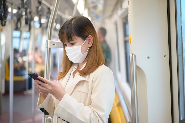 Une jeune femme porte un masque de protection dans le métro , protection contre le covid-19 , voyage de sécurité , nouvelle normalité , distanciation sociale , transport de sécurité , voyage sous le concept de pandémie