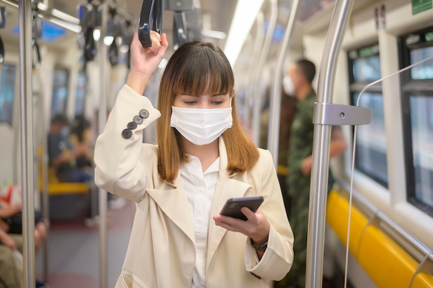 Une jeune femme porte un masque de protection dans le métro , protection contre le covid-19 , voyage de sécurité , nouvelle normalité , distanciation sociale , transport de sécurité , voyage sous le concept de pandémie