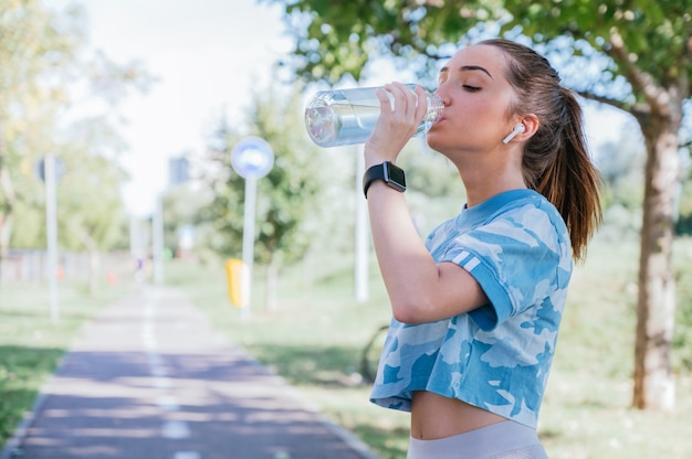 Jeune femme, porter, sportswear, eau potable