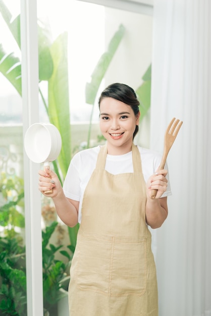 jeune femme, porter, tablier cuisine, à, casserole