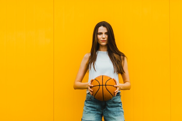 Photo jeune femme posant avec basketball