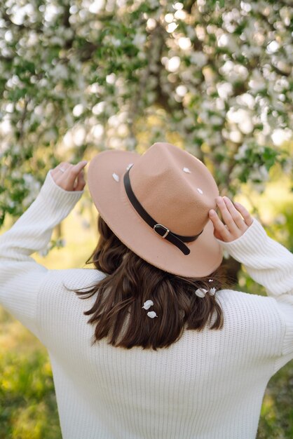 Jeune femme posant dans des fleurs de fleurs de printemps dans un jardin fleuri