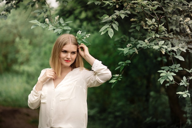 Jeune femme posant dans la forêt de printemps