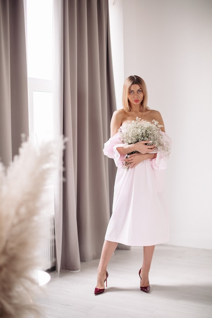 Jeune femme posant avec gros bouquet de fleurs