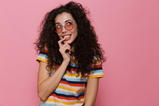 Jeune femme posant isolée sur rose à côté.