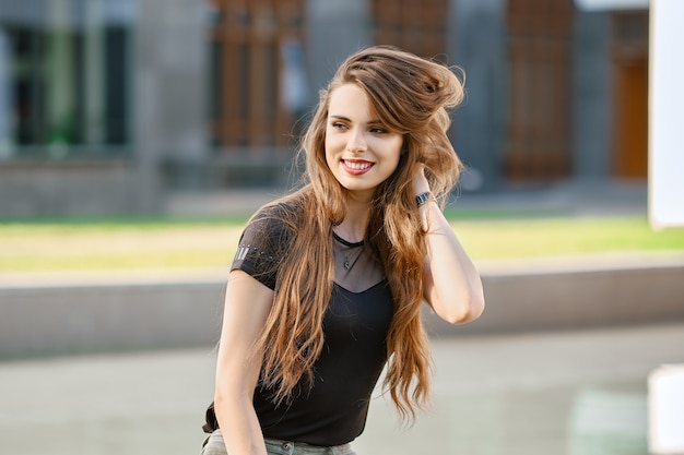 Jeune femme positive et heureuse aux longs cheveux bouclés