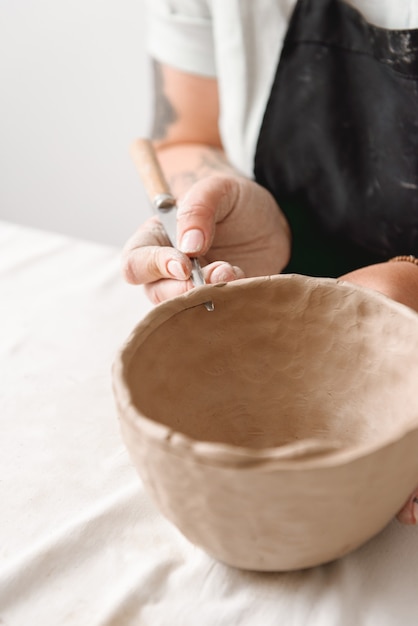 Jeune femme en pot de terre en atelier de poterie