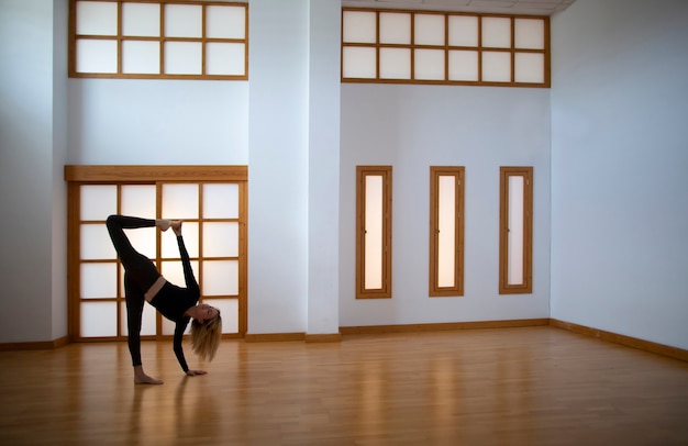 Jeune femme pratiquant le yoga dans une chambre de style japonais