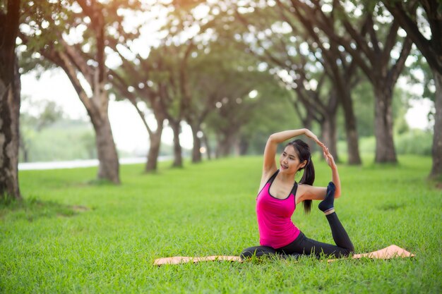 Jeune femme pratiquant l&#39;yoga dans le parc