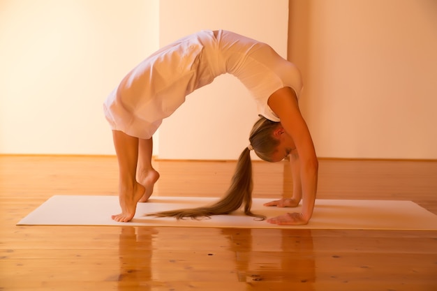 Une jeune femme pratiquant le yoga dans un studio mansardé.