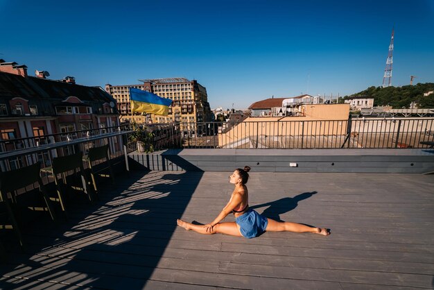Jeune femme pratiquant le yoga sur le toit d'un immeuble