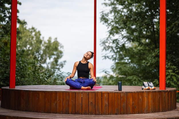 Jeune femme pratique le yoga assis dans la position du lotus