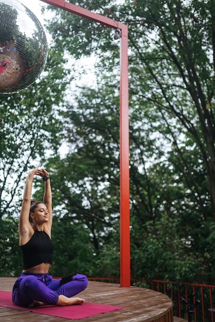 Jeune femme pratique le yoga assis dans la position du lotus