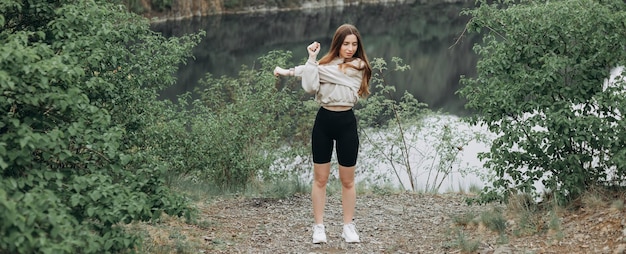 La jeune femme pratique le yoga au lac de montagne