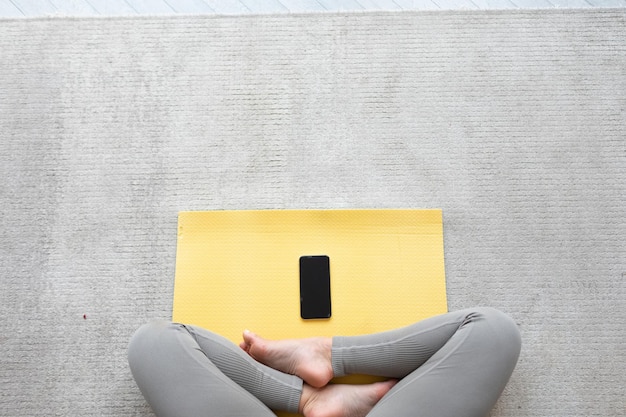 Jeune femme pratique le yoga à la maison avec tablet pc