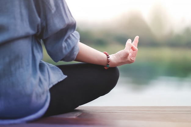 Jeune femme pratique le yoga en plein air. Assis en position Lotus.