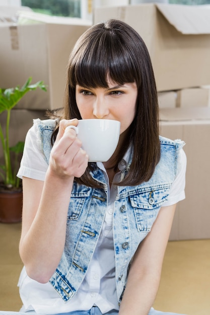 Jeune femme prenant un café dans sa nouvelle maison