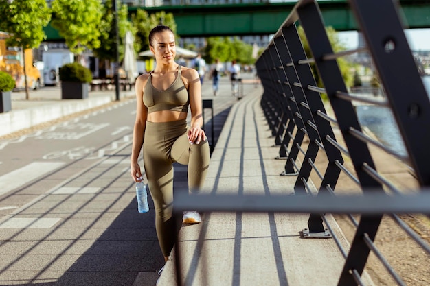 Jeune femme prenant une pause pendant l'exercice sur la promenade de la rivière