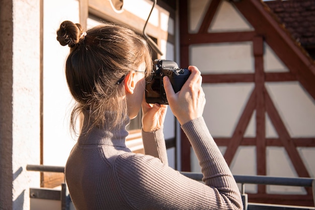 Jeune femme prenant des photos sur l'appareil photo dans la rue