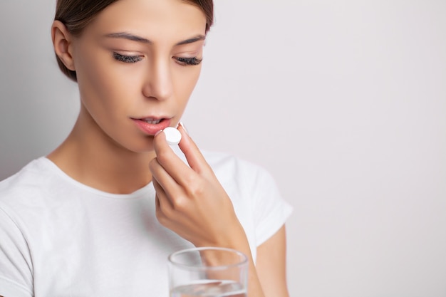 Jeune femme prenant une pilule pour un mal de tête