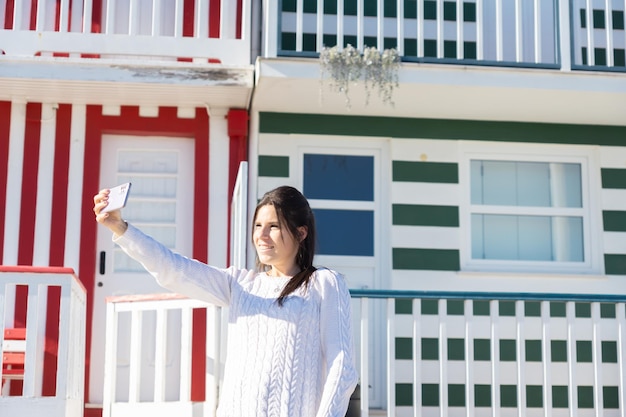 Jeune femme prenant un selfie à Costa Nova Portugal