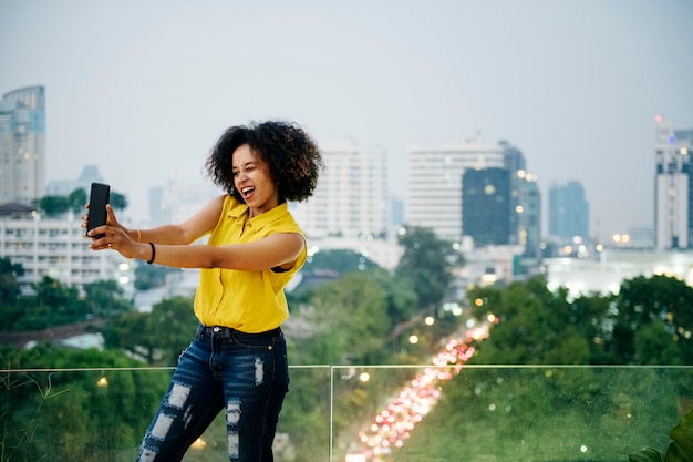 Jeune femme prenant un selfie mignon dans le paysage urbain