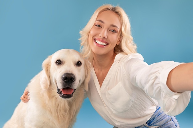 Jeune femme prenant selfie avec son chien heureux