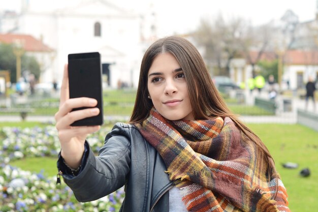 Jeune femme prenant selfie avec son smartphone.